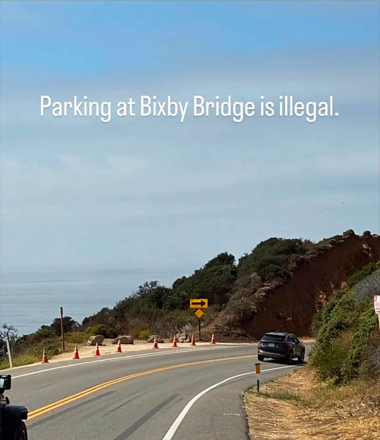 The south approach to Bixby Bridge on Highway 1, its ocean-side turnout coned off end to end.
